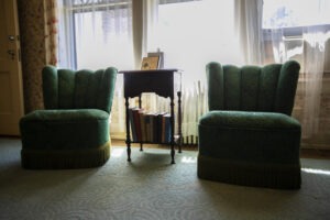 Two green vintage chairs sitting in the Alice Room at the Musser Mansion at the Linden Hill Historic Estate in Little Falls, Minnesota. Perfect space for group lodging for weddings, reunions, retreats, and other events.